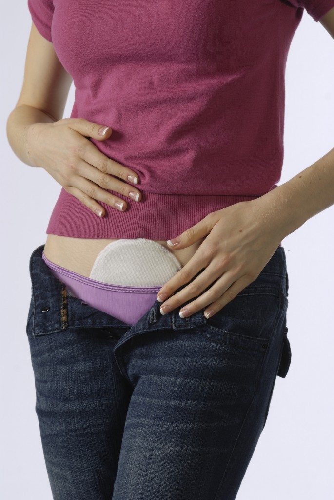 Person wearing a discreet wearable pulsed shortwave therapy device beneath everyday clothing.